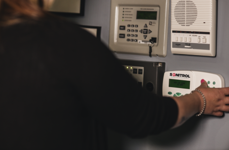 A woman pressing a code into a security system. 