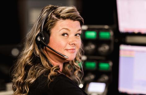 Woman wearing headset at SONITROL monitoring center.